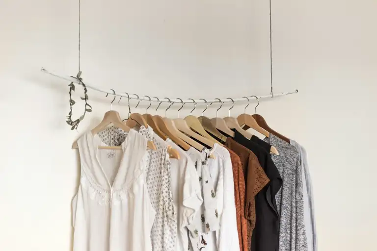 Clothes hanging on wooden hangers on a rail