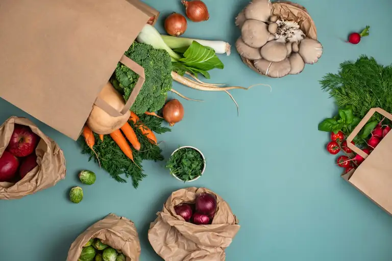Shopping bags of fresh vegetables on a table